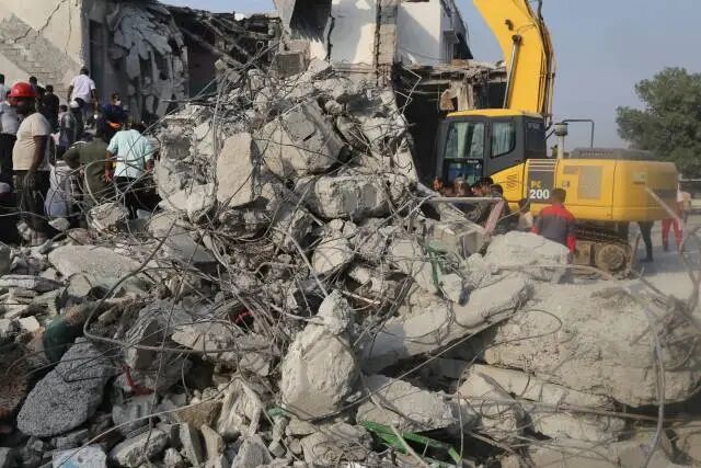 在伊朗南部米纳卜市一所被袭击的小学,救援人员和当地居民试图从废墟里营救伤员。新华社 发